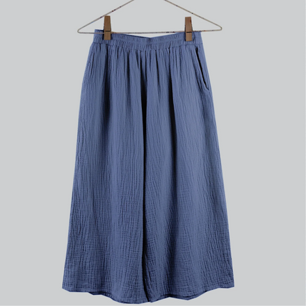 Blue skirt hanging on a hanger against a light gray background