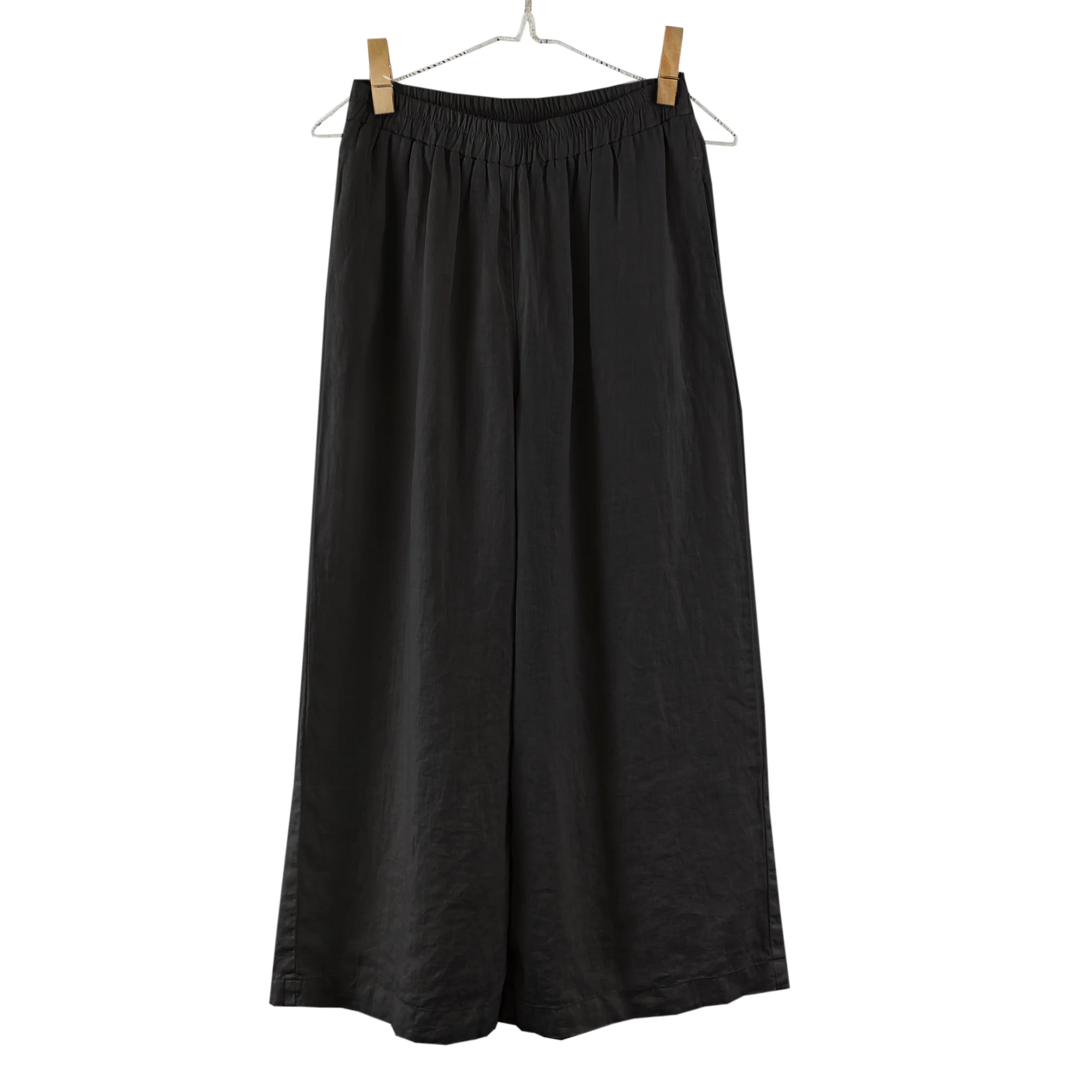 Black wide-leg pants on a hanger against a white background