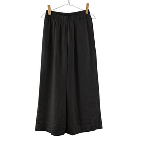 Black wide-leg pants on a hanger against a white background