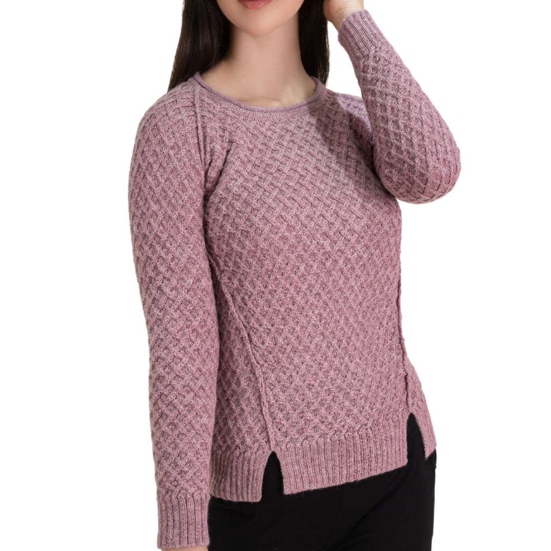 Pink knitted sweater worn by a person on a white background