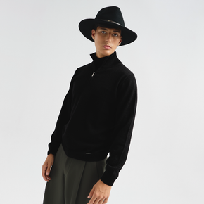 Person wearing a black sweater and hat on a white background