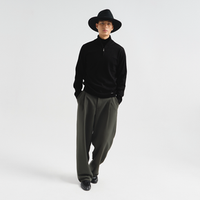 Person wearing a black outfit with a wide-brimmed hat on a white background