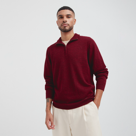 Man wearing a burgundy sweater with a white background