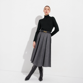 Woman wearing a black turtleneck and gray skirt on a white background