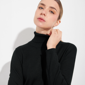 Woman wearing a black turtleneck sweater against a white background