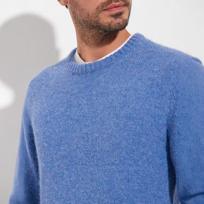 Man wearing a blue sweater against a plain background