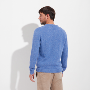 Man wearing a blue sweater against a white background