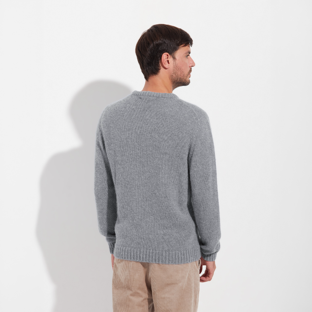 Man wearing a gray sweater against a white background