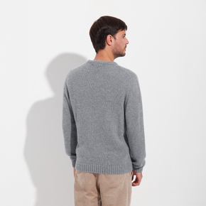Man wearing a gray sweater against a white background