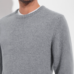 Gray sweater worn by a person on a white background