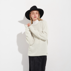 Person wearing a white sweater and black hat against a white background