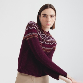 Woman wearing a patterned sweater on a plain background