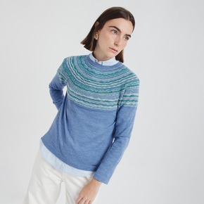 Woman wearing a blue and green patterned sweater on a white background