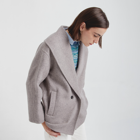 Woman wearing a gray coat on a white background
