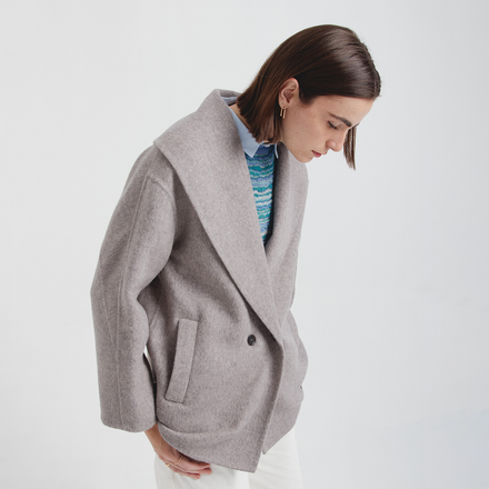 Woman wearing a gray coat on a white background