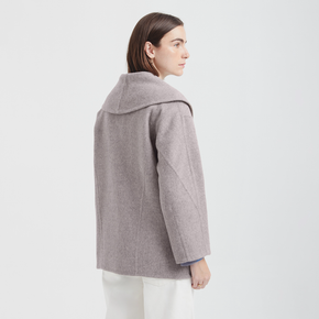 Woman wearing a gray coat on a white background