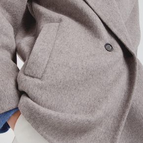 Close-up of a gray coat with a button on a neutral background