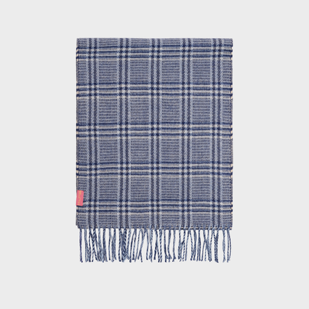 Blue plaid scarf with fringes on a light gray background