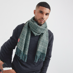 Man wearing a green plaid scarf against a plain background