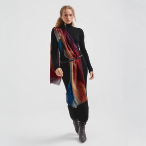 Woman wearing a colorful shawl and black outfit on a white background