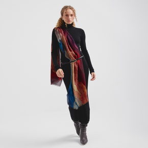 Woman wearing a colorful scarf and black outfit on a white background