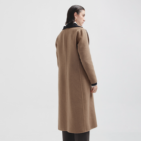 Woman wearing a long brown coat on a white background
