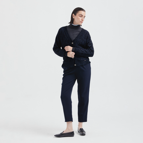 Person wearing a navy cardigan with a white background