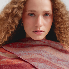 Woman with curly hair wearing a red patterned scarf