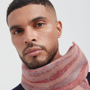 Man wearing a striped scarf against a plain background