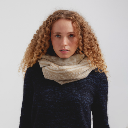 Woman wearing a beige scarf against a white background
