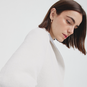 Woman wearing a white outfit with a plain background