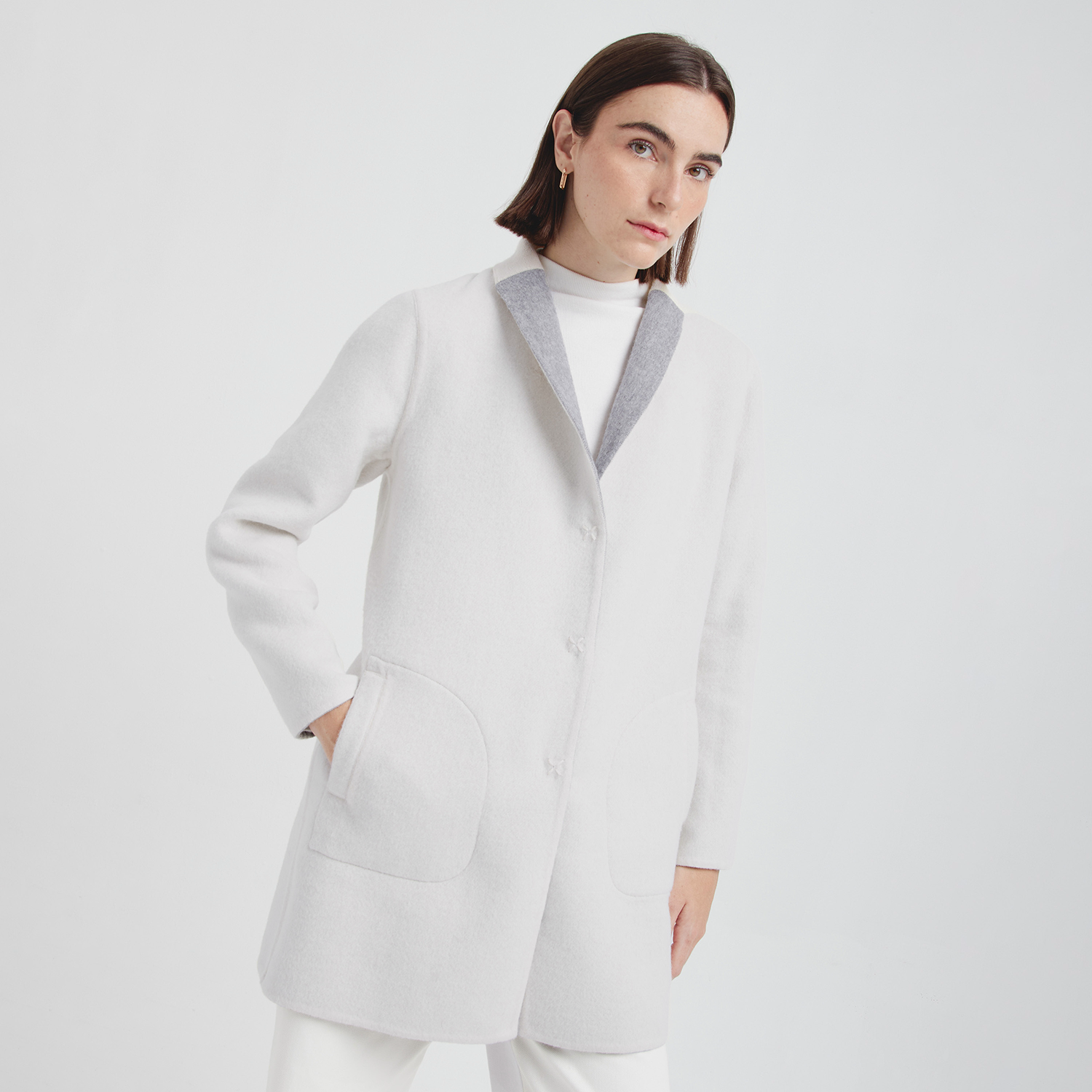 Woman wearing a white coat with a white background
