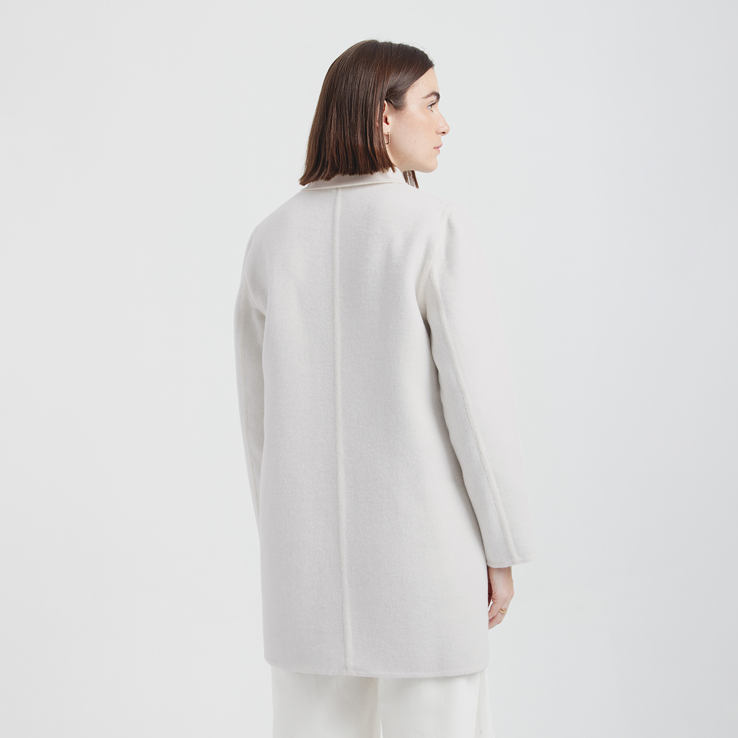 Person wearing a white coat on a white background