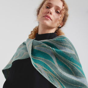 Woman wearing a teal and gray patterned scarf against a white background