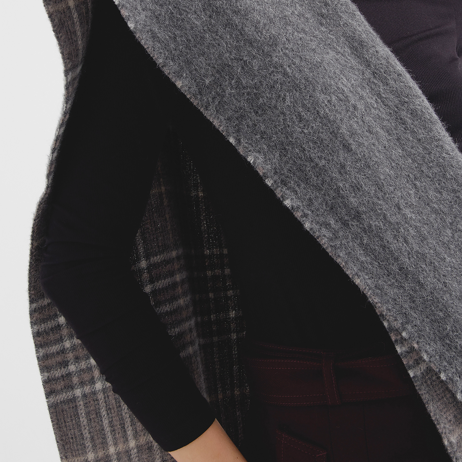 Close-up of a person wearing a dark scarf with plaid pattern on a white background