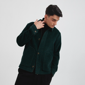 Man wearing a dark green jacket on a light gray background