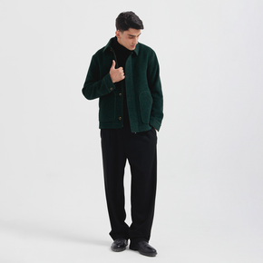 Man wearing a green jacket over a black shirt on a white background