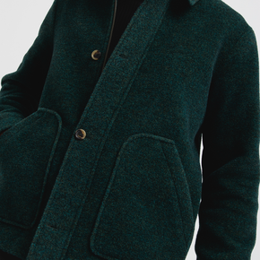 Close-up of a dark green coat with buttons on a light gray background