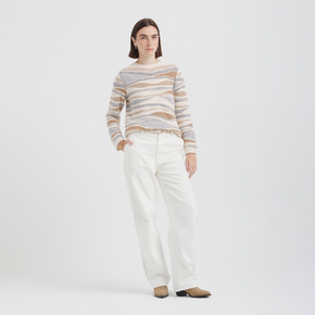 Woman wearing a striped sweater and white pants on a white background