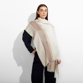 Woman wearing a beige and brown striped scarf on a white background