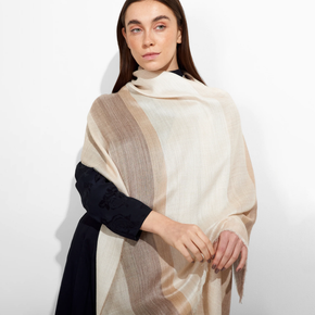 Woman wearing a beige and brown striped shawl on a white background