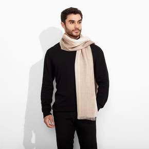 Man wearing a black sweater and beige scarf on a white background