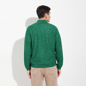 Man wearing a green sweater and beige pants on a white background