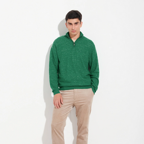 Man wearing a green sweater and beige pants on a white background