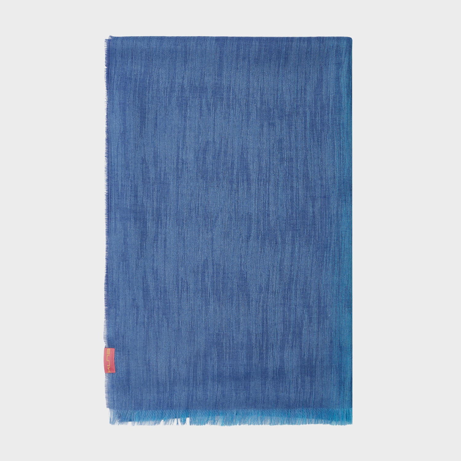 Blue shawl with a red tag on a light gray background