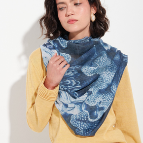Woman wearing a blue abstract patterned scarf on a white background