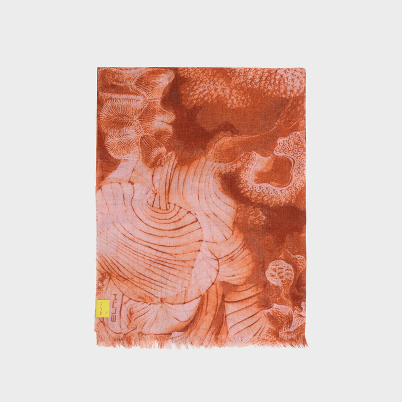 Decorative orange shawl with abstract pattern on a light gray background