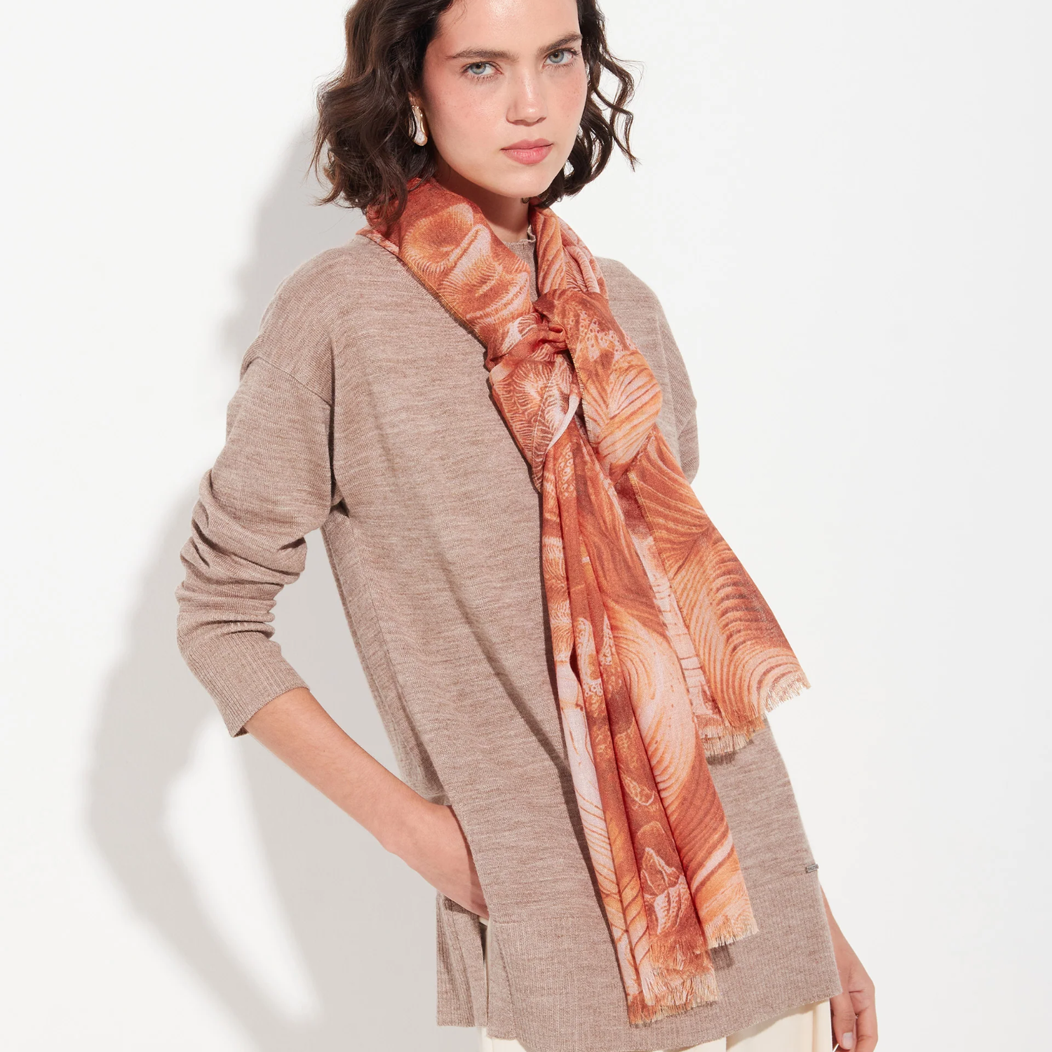 Woman wearing a patterned orange scarf on a white background