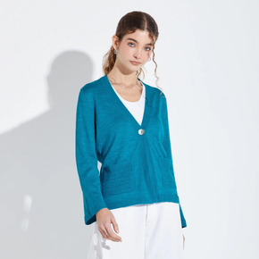 Woman wearing a teal cardigan over a white shirt on a light gray background