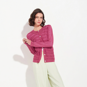 Woman wearing a pink textured cardigan on a white background